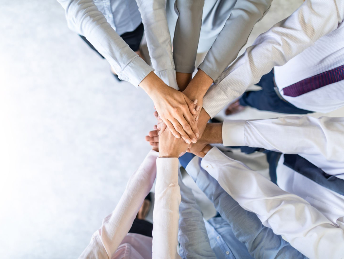 Close up top view of young business people putting their hands together. Stack of hands. Unity and teamwork concept.